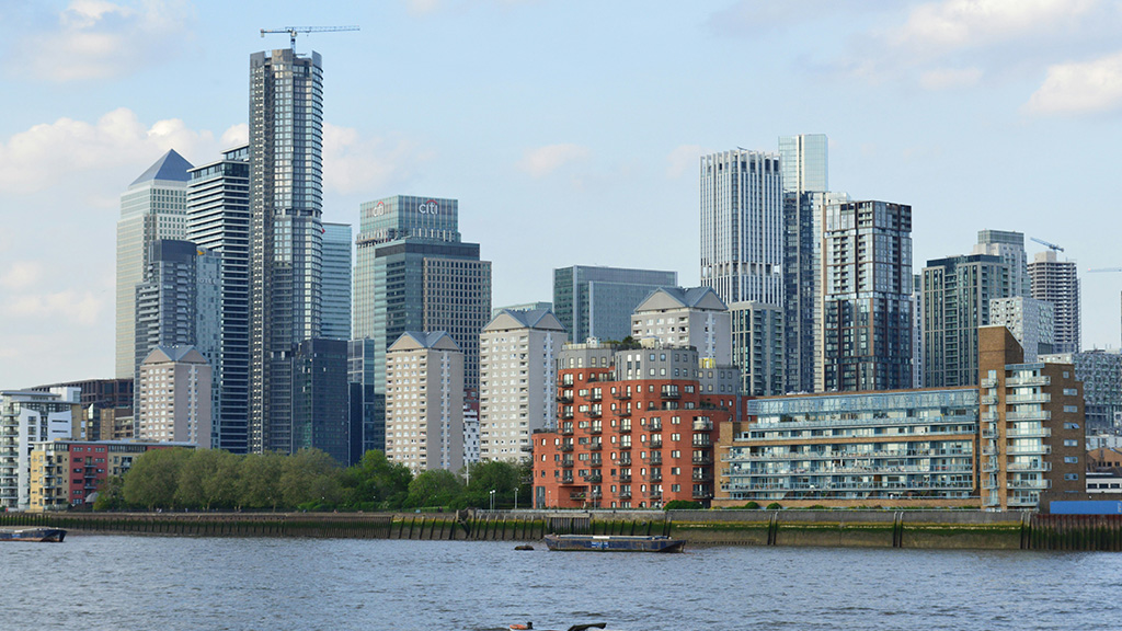 Tall buildings by the river Thames. Photo by Junni Baba on Unsplash https://unsplash.com/photos/a-boat-floating-on-top-of-a-lake-next-to-tall-buildings-vsZfz96I_04